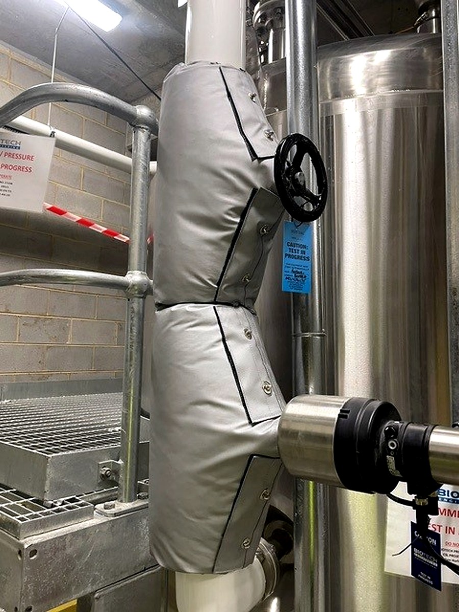 Close-up of a fitted removable thermal jacket on a process valve in a clean plant room